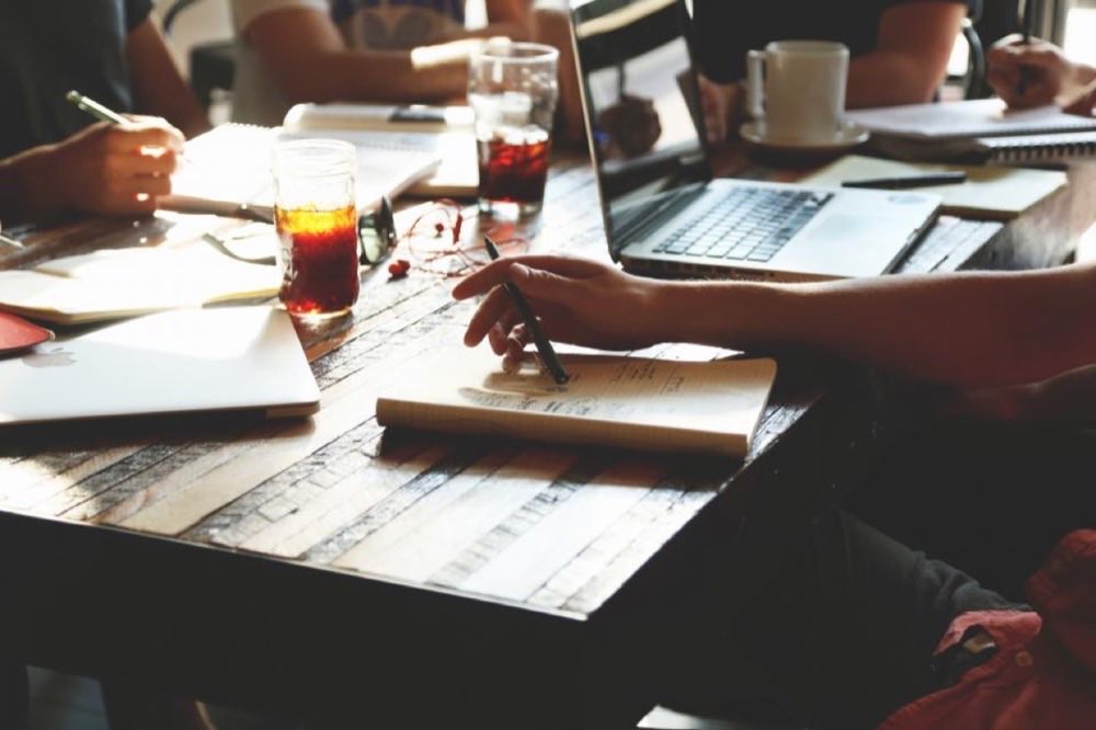 Documents, a laptop and coffee on a meeting table